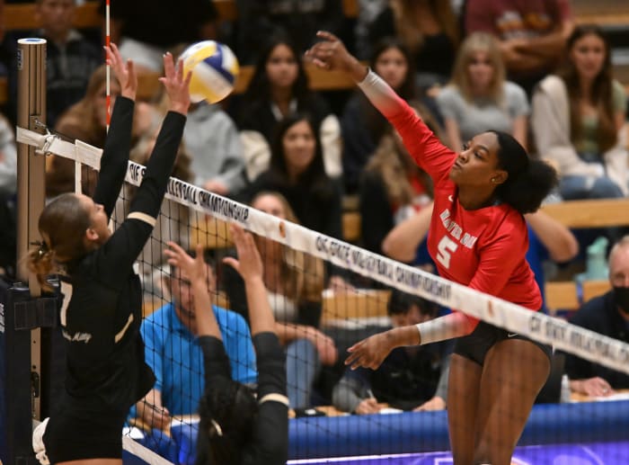 Cymarah Gordon (5) hits into the block of Mitty's Katelyn Cook (7).